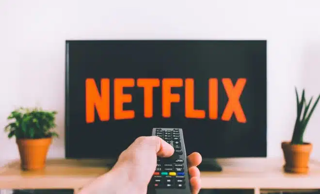 person holding remote pointing at TV