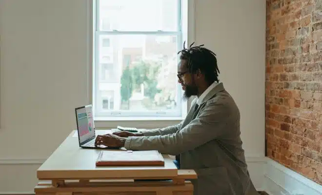 a person sitting at a desk with a laptop and papers